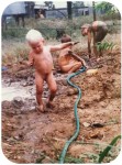 Young Baz playing in the mud with no clothes on