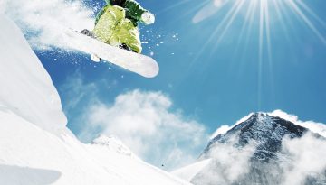 Snowboarder at jump inhigh mountains